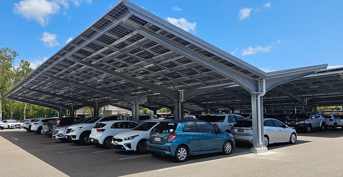 View of a CSE Linked EcoPort Carpark solution with a line of cars parked under the solar structure